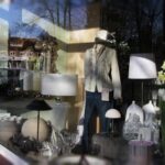 Boutique storefront window display with minimal merchandising, soft lighting, mannequins, and uncluttered product presentation designed to attract shoppers.