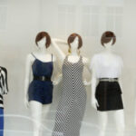 Mannequins displayed near the storefront entrance to attract customers and showcase featured apparel collections.
