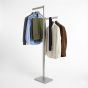 Retail display rack satin chrome two-way clothing stand with adjustable height arms - shown in use