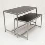 Retail nesting display table set with steel frames and black laminate tops, viewed from a left 3/4 angle
