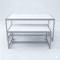 Retail nesting display table set with steel frames and white laminate tops, viewed from the front